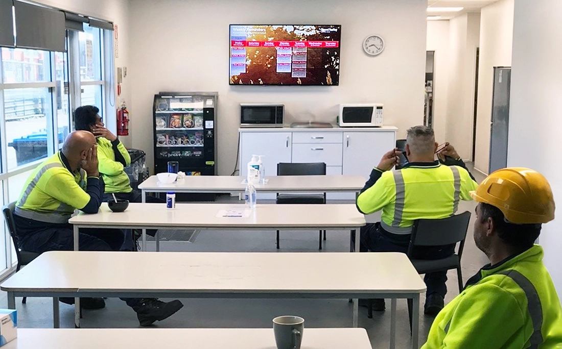 Digital screen in a common area displaying company news