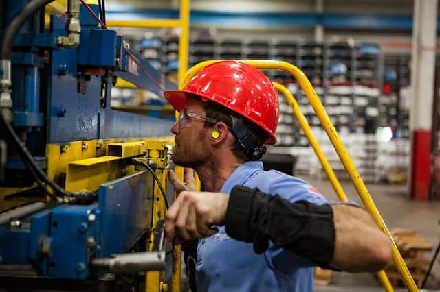 worker with earplugs in a manufacturing workplace