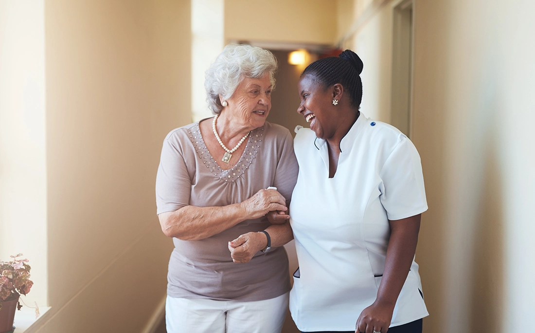 Elderly resident being assisted by a caregiver in an aged care facility