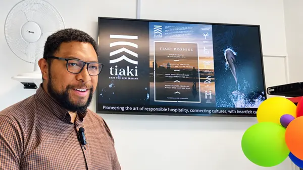 Hotel employee in a staff room beside a Vibe communication screen