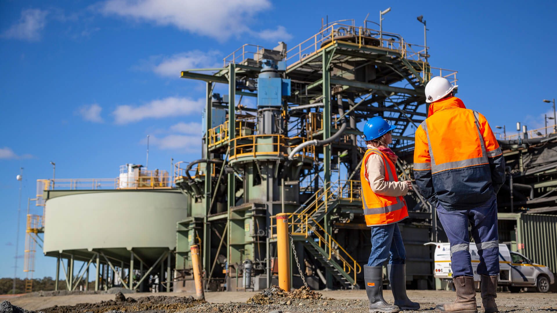 two people at a processing plant looking upwards